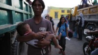Un père et son fils s'apprêtent à évacuer la ville d'Esperanza (sud des Philippines) dans une zone attaquée par les rebelles des Combattants pour la liberté du Bangsamoro islamique (Biff), le 1er janvier 2016.