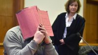 L'infirmier, Niels Högel, cache son visage derrière un dossier lors de l'ouverture d'un précédent procès à côté de son avocat Ulrike Baumann, le 26 février 2015.